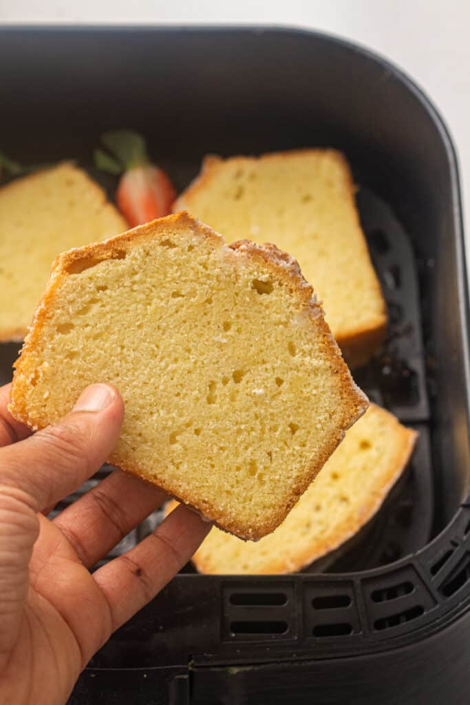 Hand holding a slice of the air fryer pound cake 