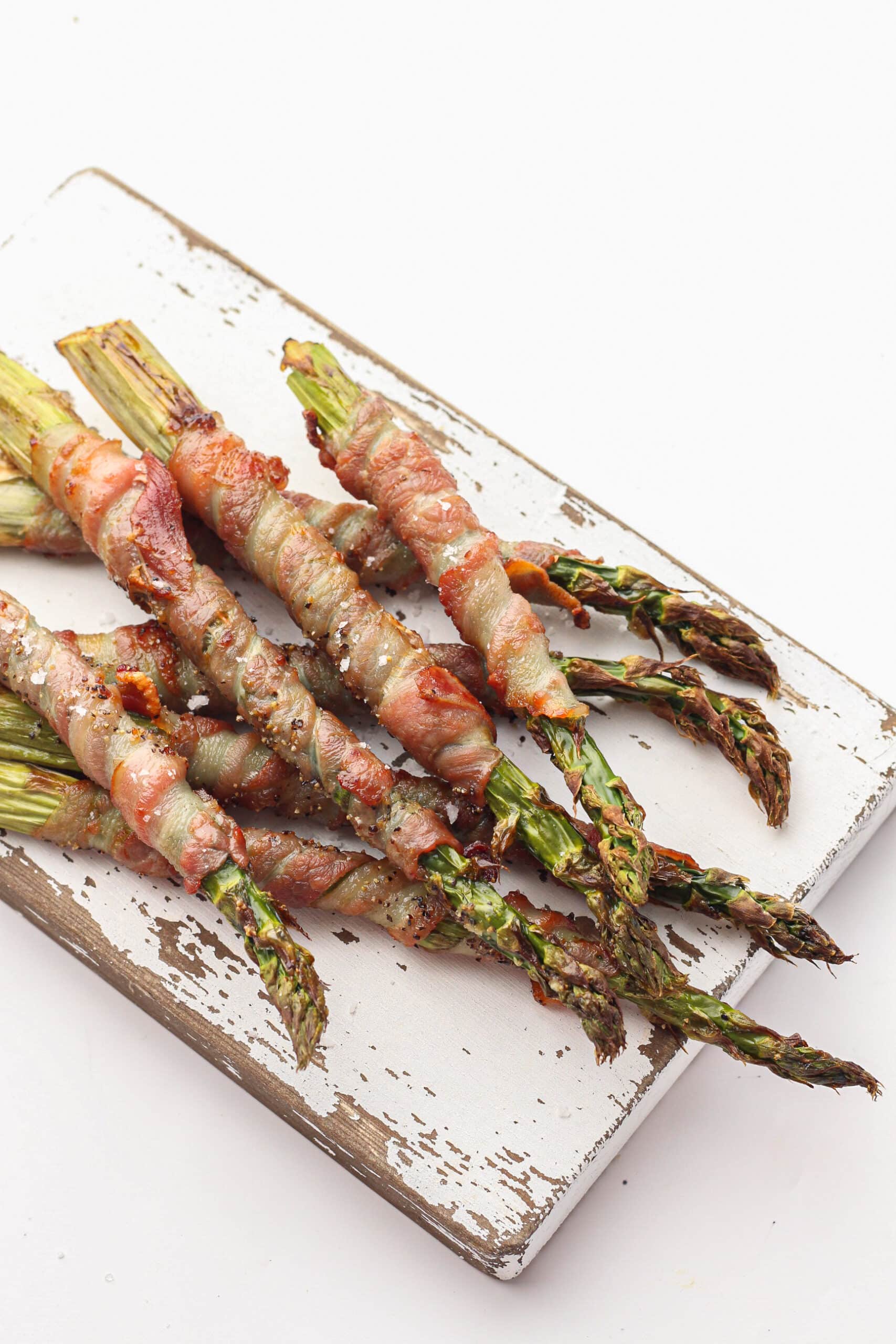 Air fryer Bacon wrapped asparagus on a chopping board