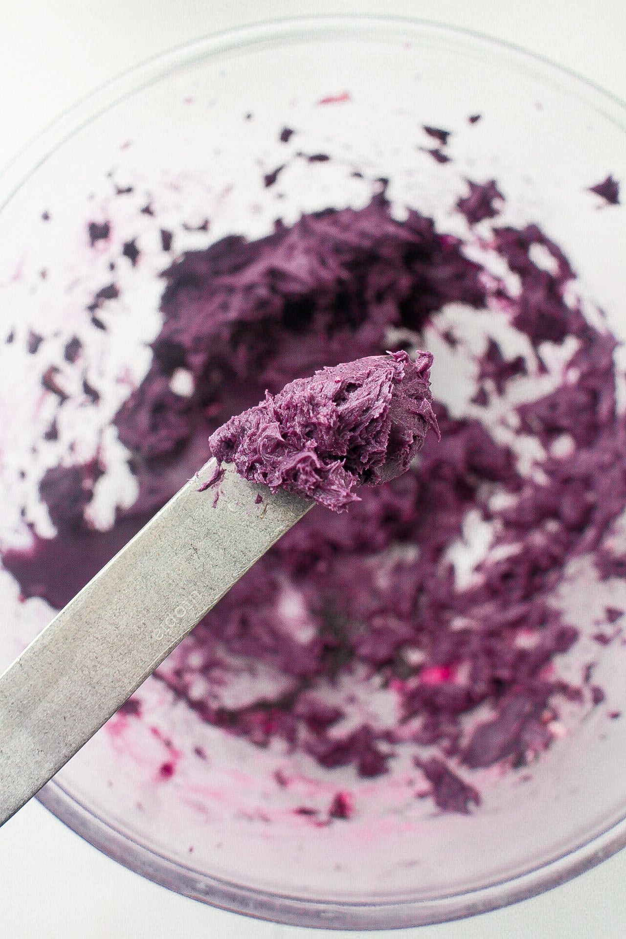 ube butter on a knife ready to spread