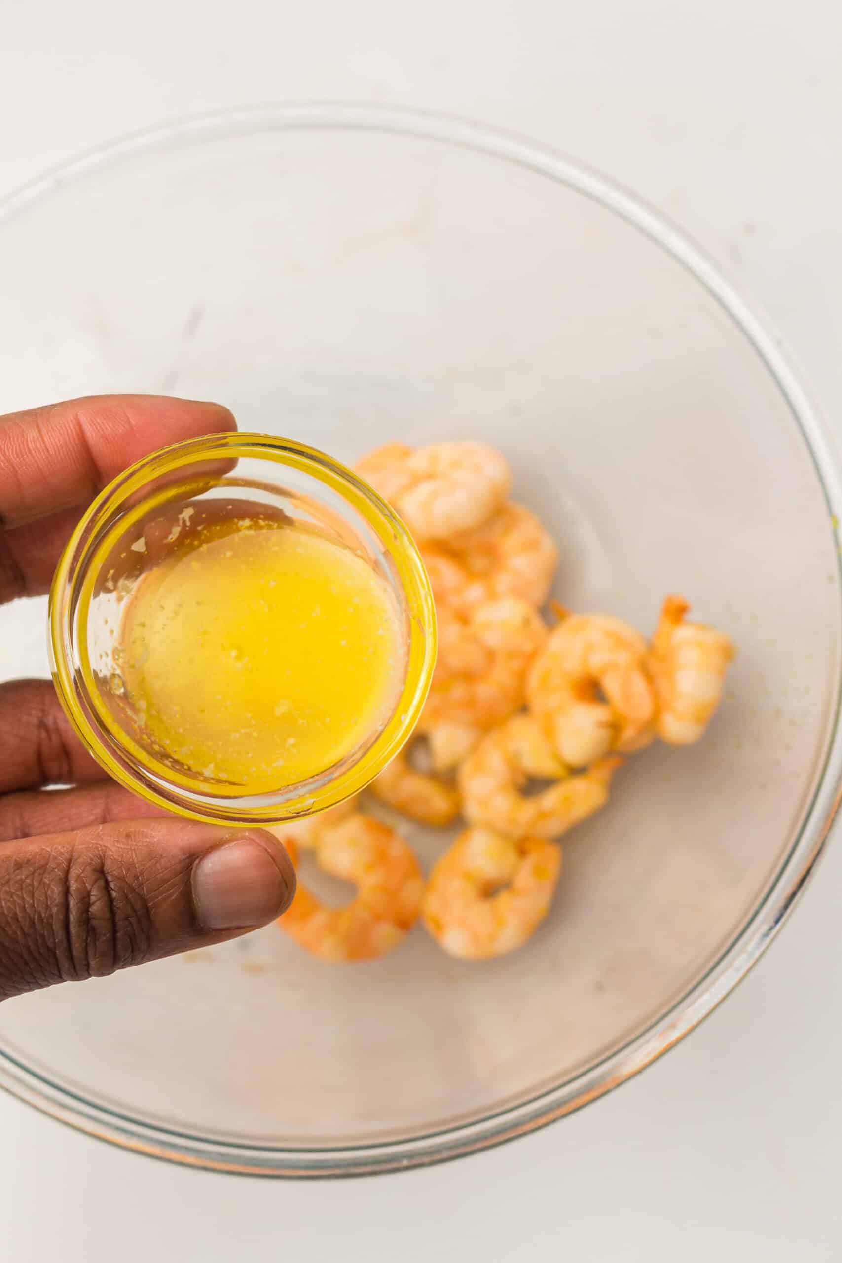 Cooked shrimp being coated in butter 