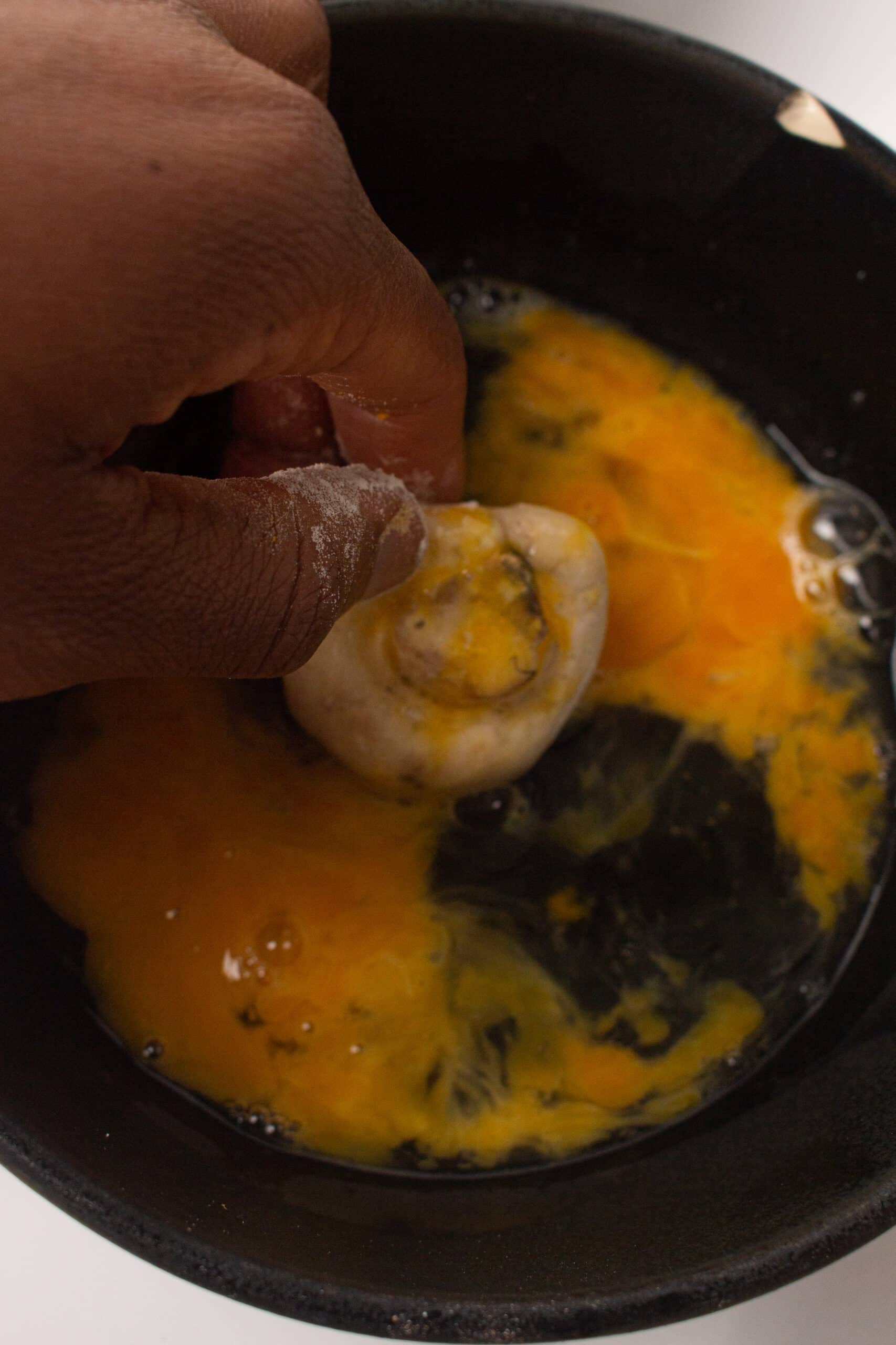 Dipping the mushrooms in the egg mixture 