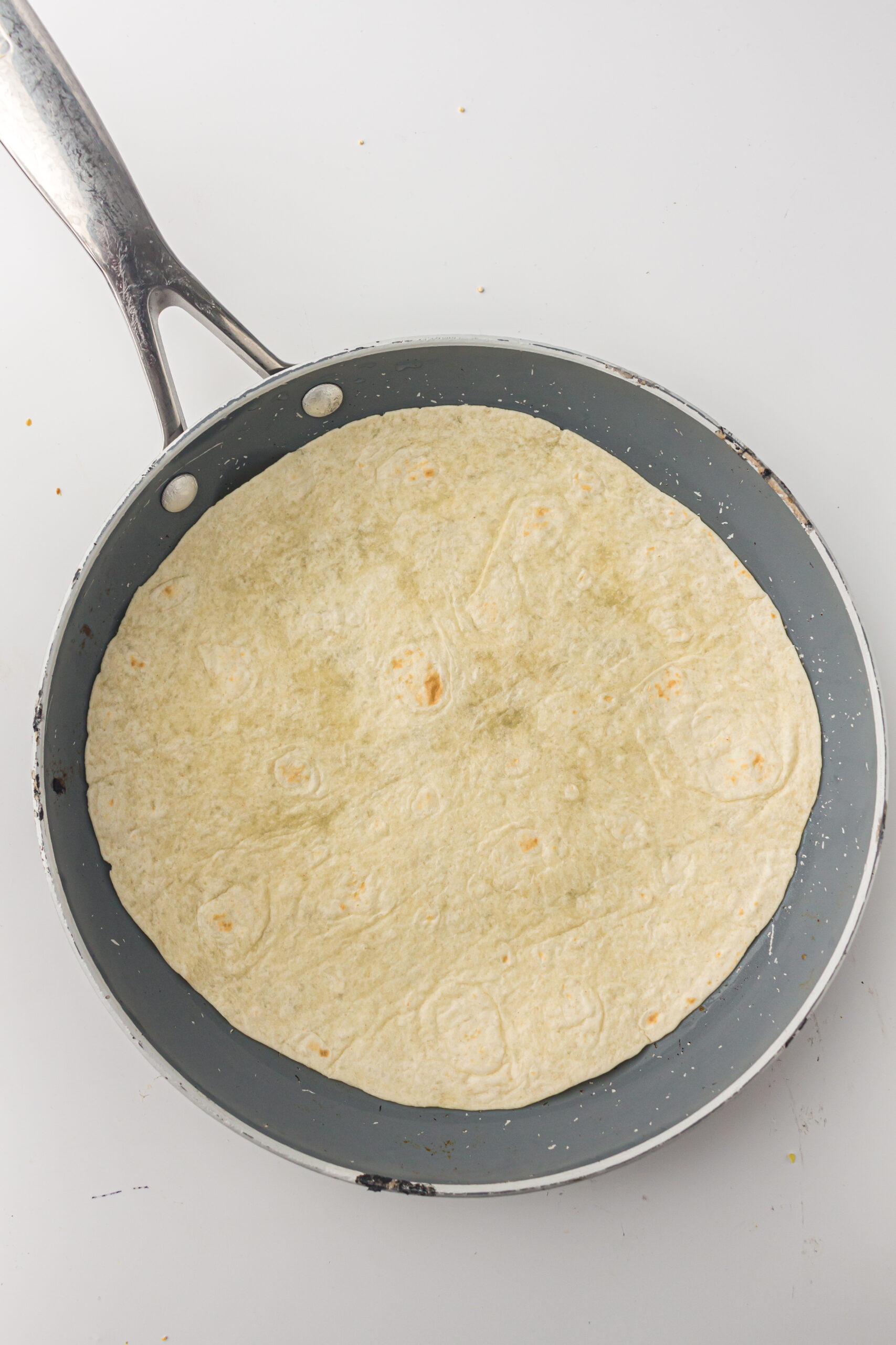 Place the tortilla in the pan